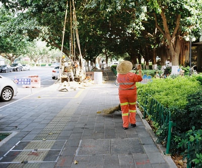 女人在橙色和黄色衣服站在灰色的水泥地上白天
